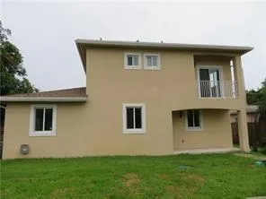 a backyard of a house with potted plants and wooden fence