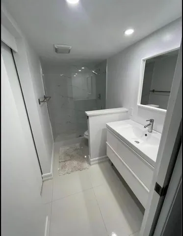 a bathroom with a sink a toilet and shower