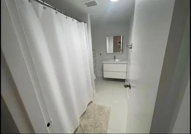 a bathroom with a sink a mirror and a shower