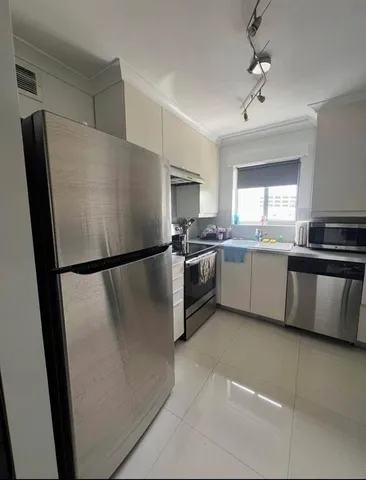 a kitchen with granite countertop a refrigerator a sink a stove and cabinets