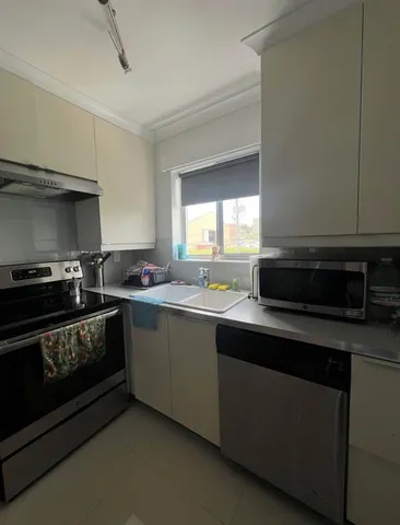 a kitchen with stainless steel appliances a stove a sink and a microwave