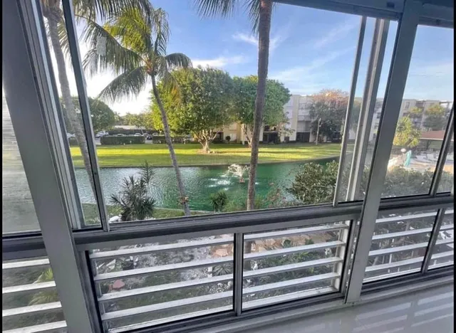 a view of backyard with large window and wooden floor