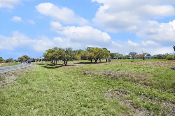 a view of a green field with wooden fence