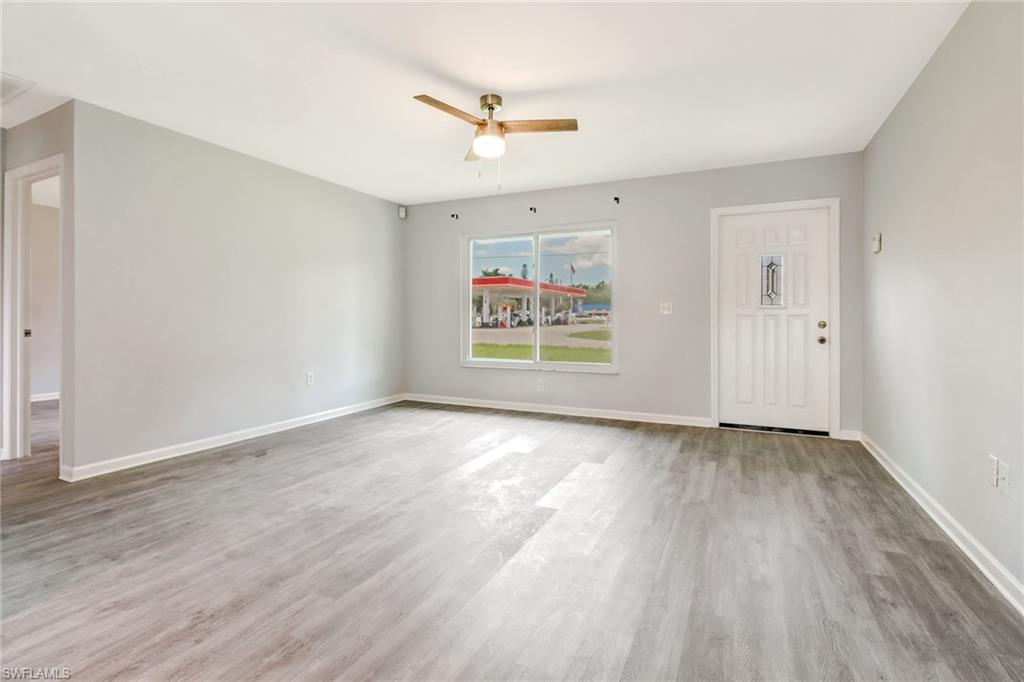 19161 Acorn Road Fort Myers, FL 33967 - Photo 3 of 23 an empty room with wooden floor ceiling fan and windows