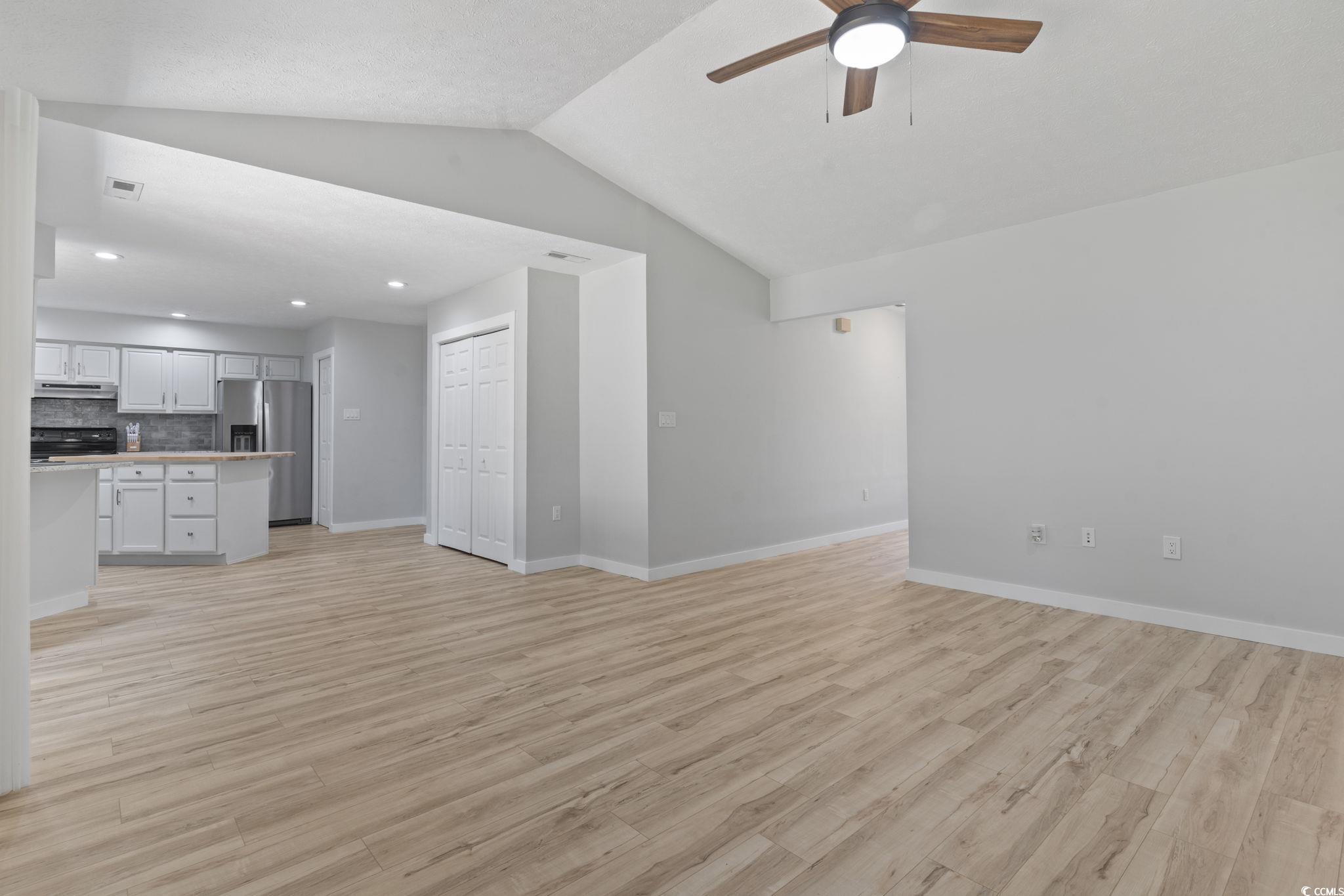 220 Rice Mill Drive Myrtle Beach, SC 29588 - Photo 11 of 31 Unfurnished living room with lofted ceiling, ceiling fan, light wood finished floors, and recessed lighting