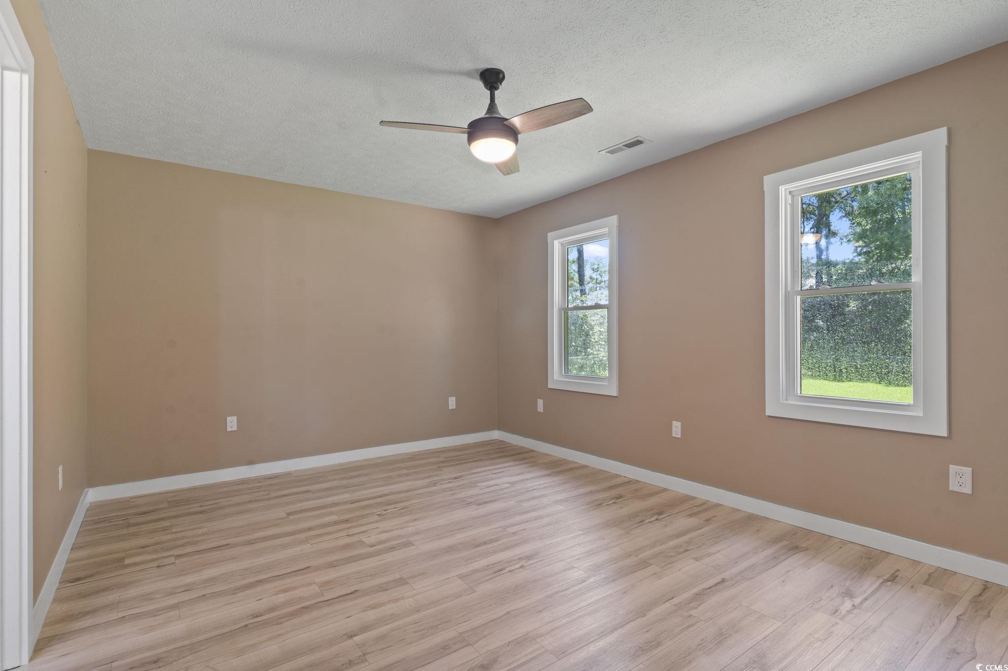 220 Rice Mill Drive Myrtle Beach, SC 29588 - Photo 15 of 31 Empty room featuring light wood-type flooring, a ceiling fan, and a textured ceiling