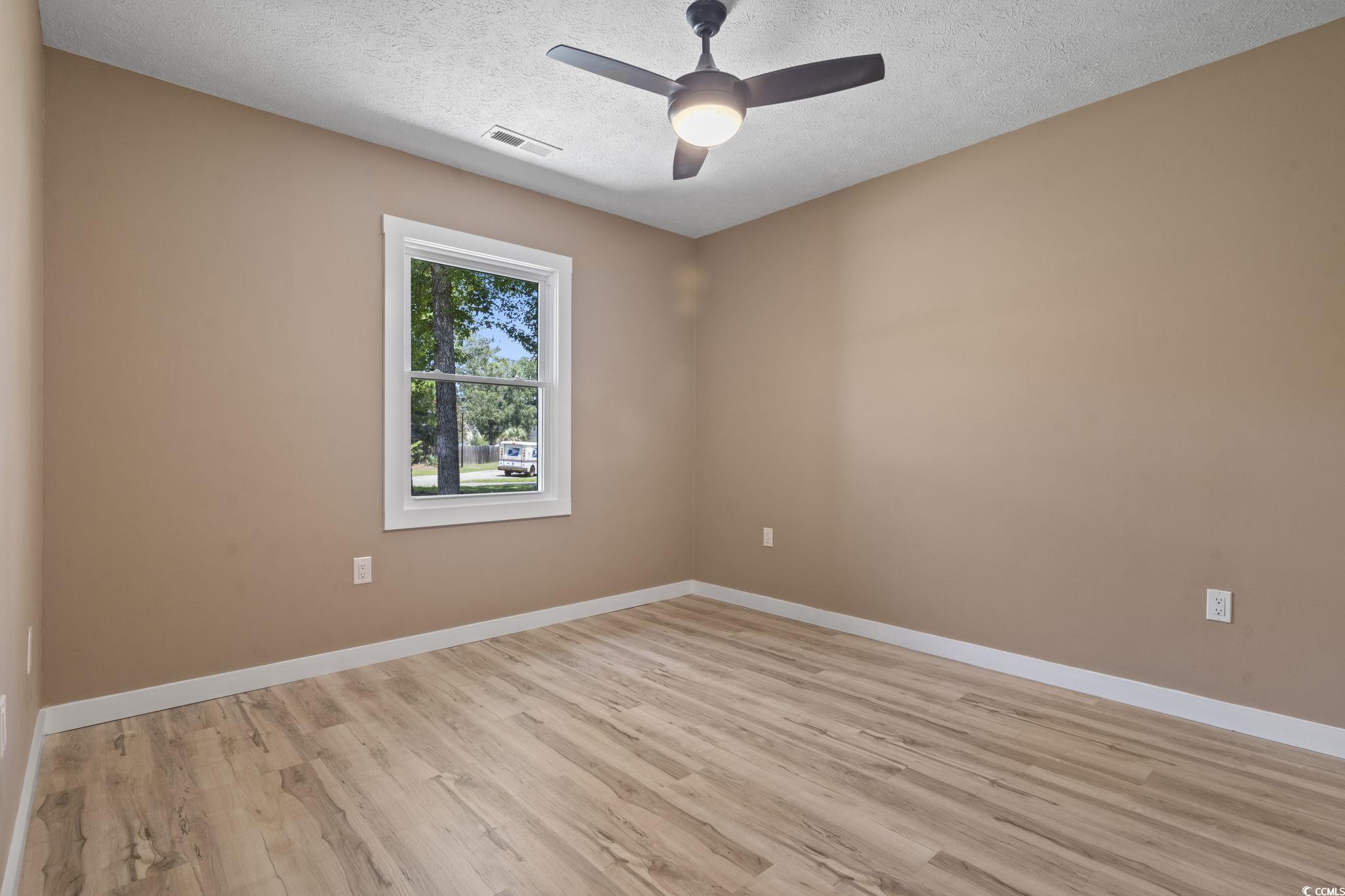 220 Rice Mill Drive Myrtle Beach, SC 29588 - Photo 18 of 31 Empty room featuring light wood finished floors, a textured ceiling, and ceiling fan