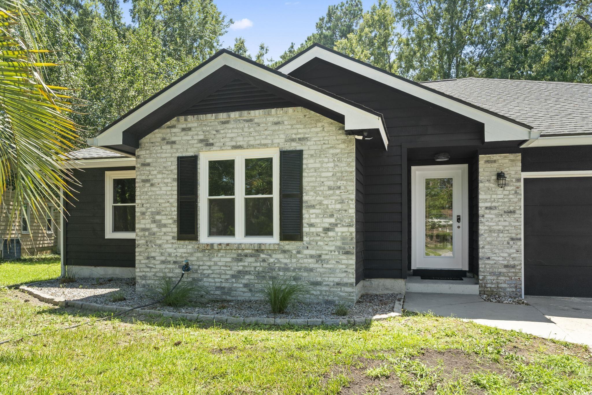 220 Rice Mill Drive Myrtle Beach, SC 29588 - Photo 2 of 31 View of front of property with an attached garage, a front lawn, and brick siding