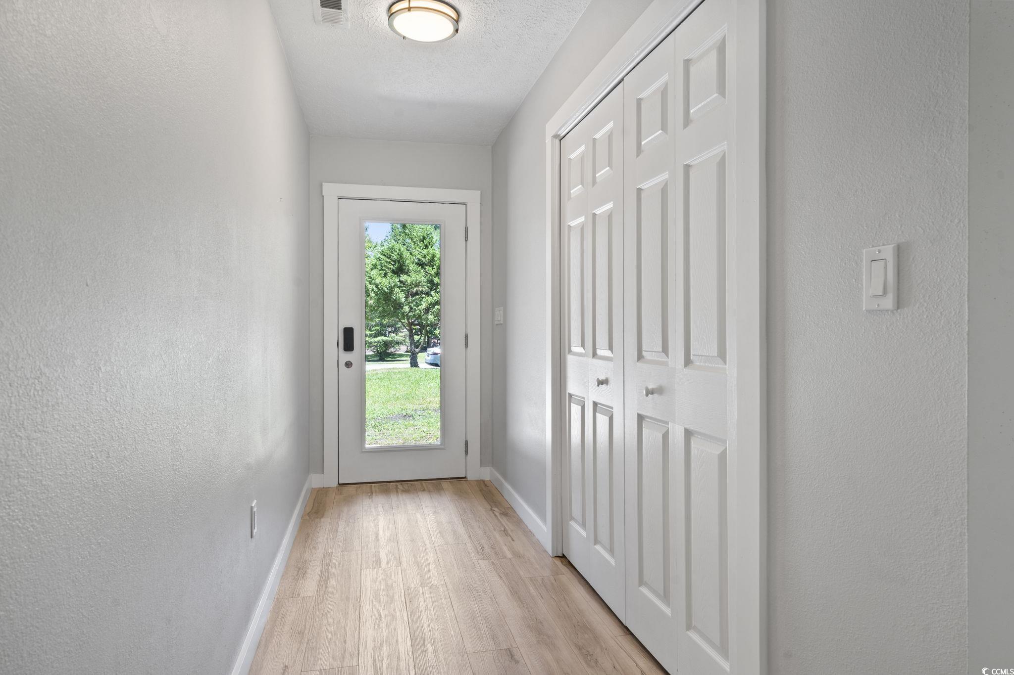 220 Rice Mill Drive Myrtle Beach, SC 29588 - Photo 22 of 31 Entryway with a textured wall, light wood-style flooring, and a textured ceiling