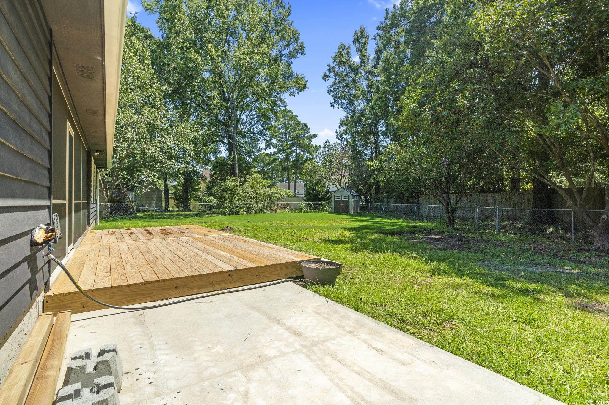 220 Rice Mill Drive Myrtle Beach, SC 29588 - Photo 24 of 31 Fenced backyard with a storage unit, a wooden deck, and a patio area
