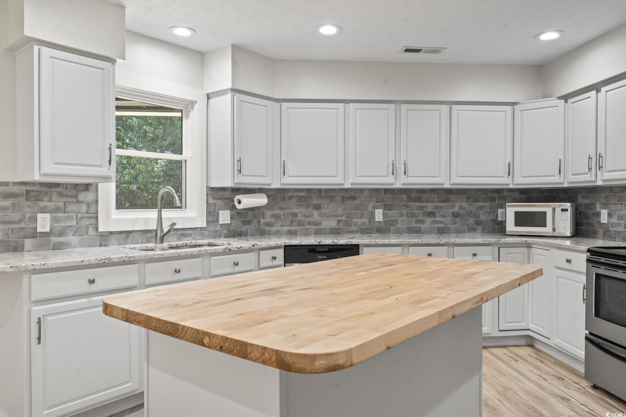 220 Rice Mill Drive Myrtle Beach, SC 29588 - Photo 7 of 31 Kitchen with wood counters, tasteful backsplash, stainless steel electric range oven, white microwave, and recessed lighting