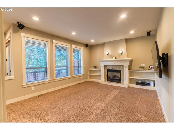 a view of an empty room with a fireplace and a window