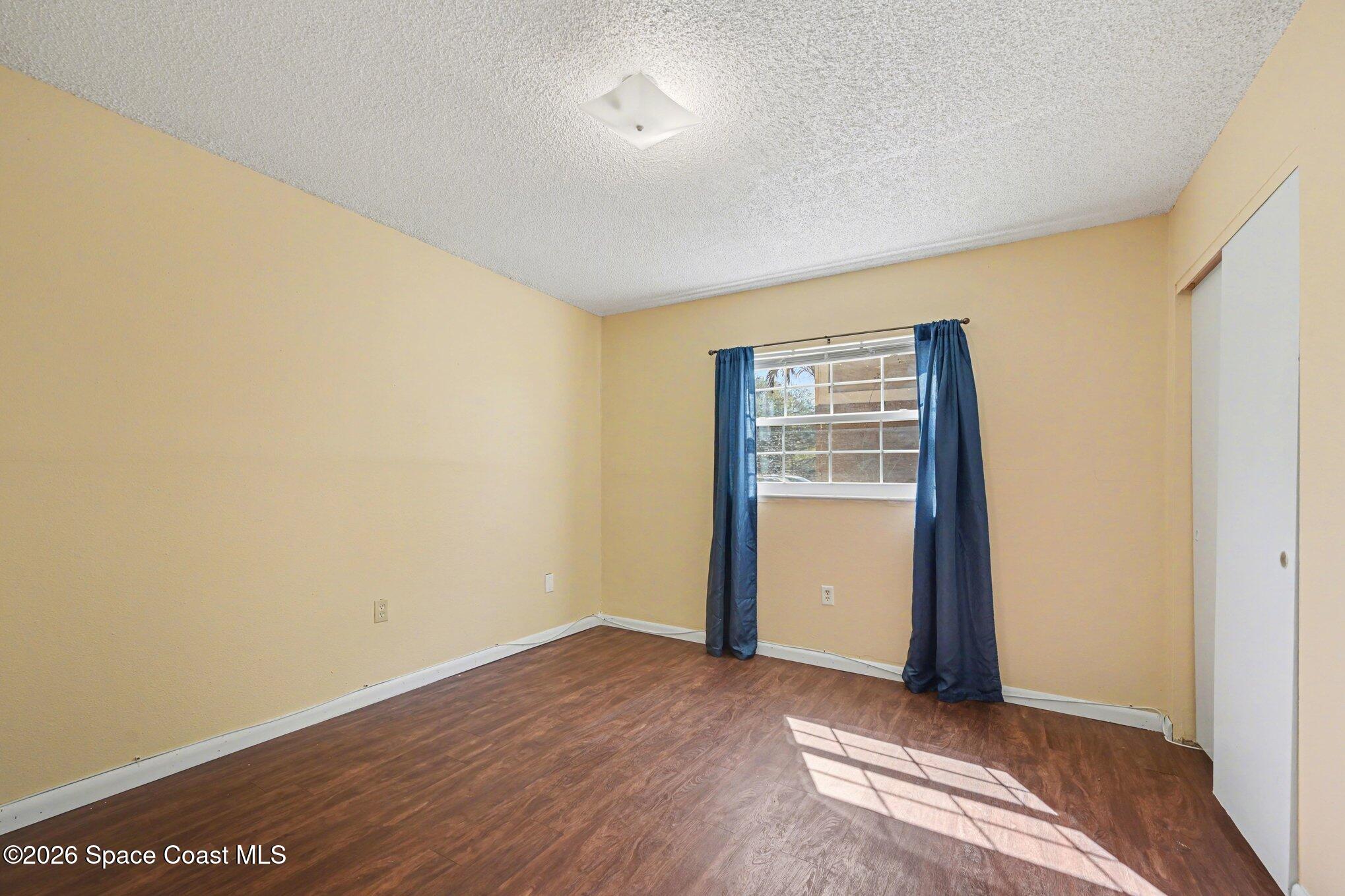 101 Bristol Lane, Unit 101 Melbourne, FL 32935 - Photo 11 of 16 a view of an empty room with wooden floor and a window