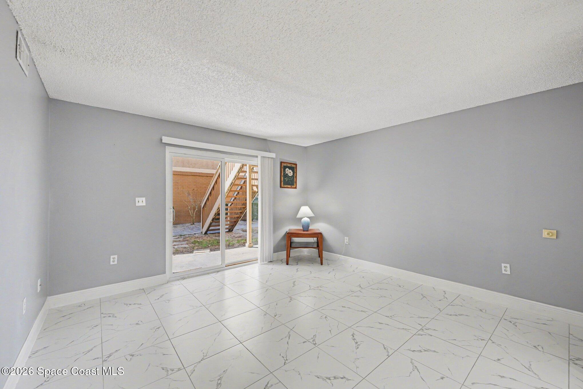 101 Bristol Lane, Unit 101 Melbourne, FL 32935 - Photo 3 of 16 an empty room with wooden floor and windows