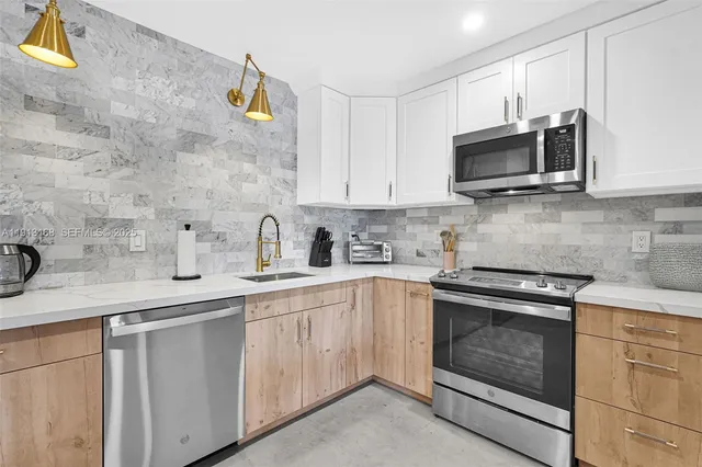 a kitchen with cabinets stainless steel appliances and sink