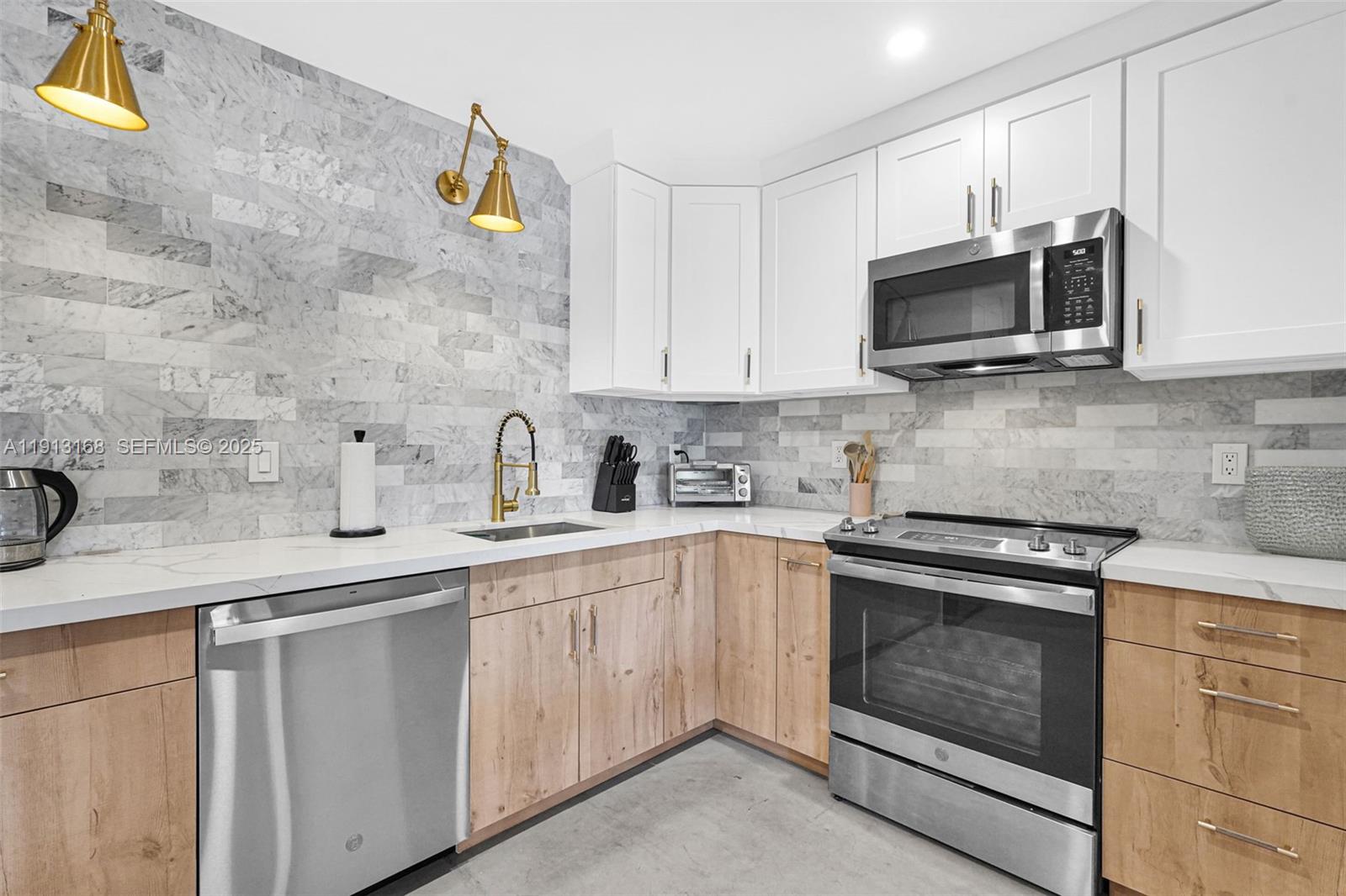 a kitchen with cabinets stainless steel appliances and sink