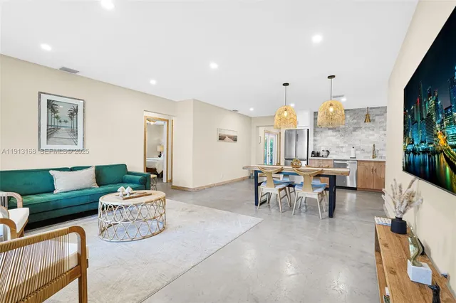 a kitchen with stainless steel appliances a refrigerator a stove a sink a dining table and chairs