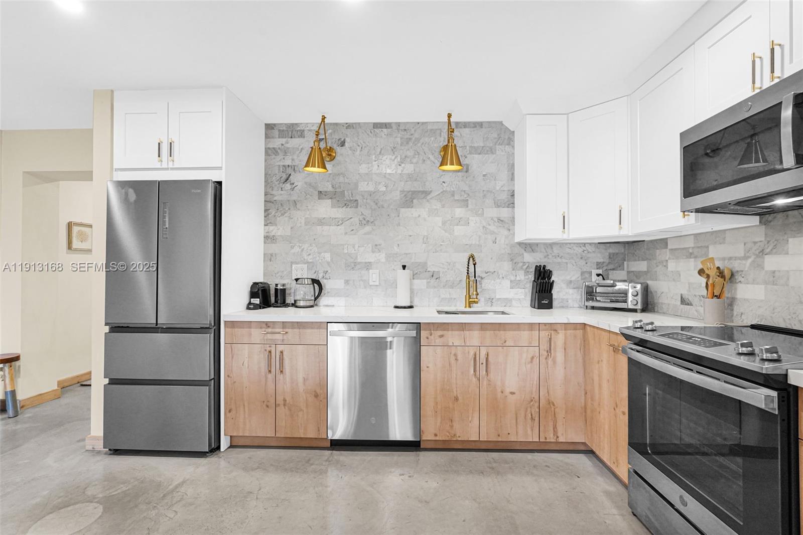 1012 Northeast 2nd Street Hallandale Beach, FL 33009 - Photo 17 of 65 a kitchen with stainless steel appliances granite countertop a refrigerator a stove a sink and white cabinets