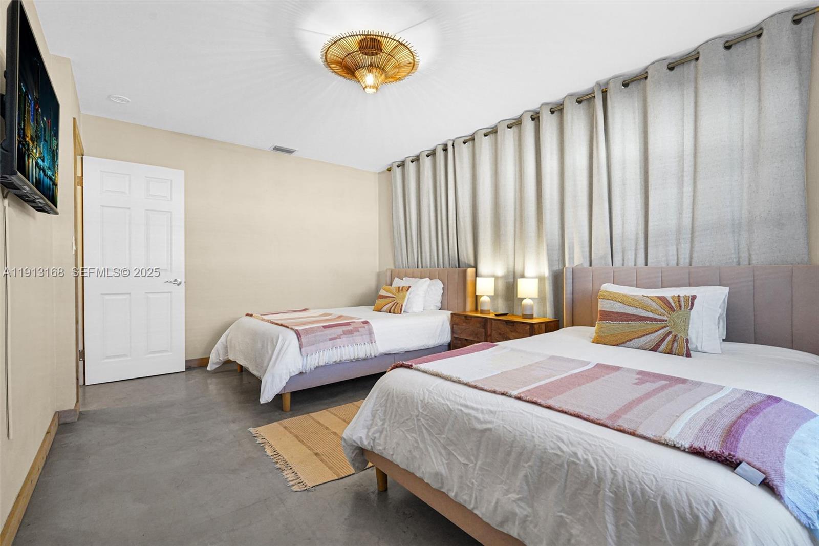 1012 Northeast 2nd Street Hallandale Beach, FL 33009 - Photo 25 of 65 a bedroom with two beds and a chandelier