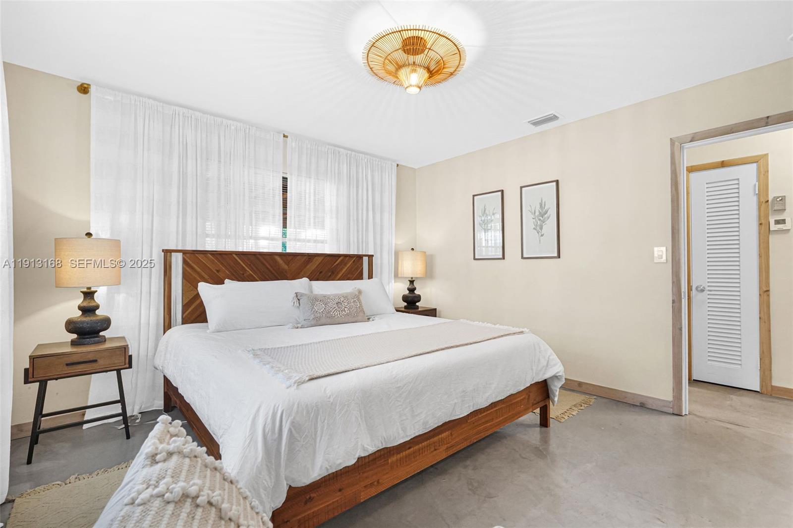 1012 Northeast 2nd Street Hallandale Beach, FL 33009 - Photo 28 of 65 a bedroom with a bed and a chandelier