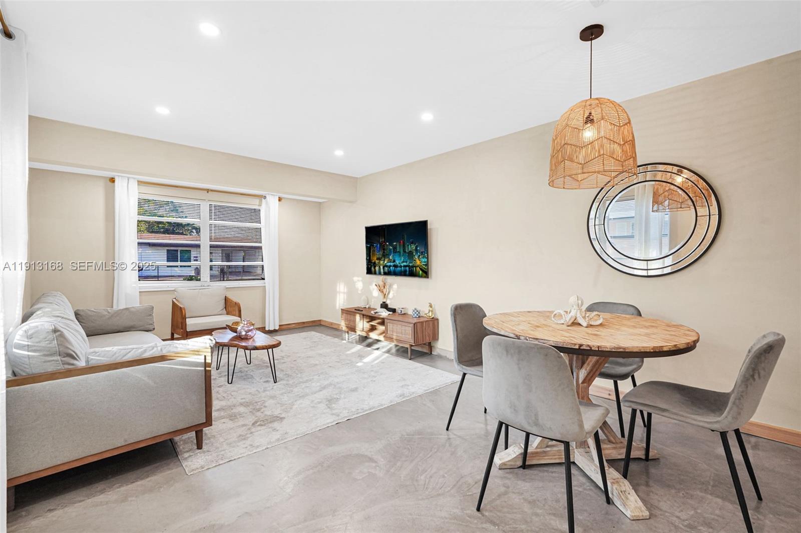 1012 Northeast 2nd Street Hallandale Beach, FL 33009 - Photo 35 of 65 a living room with furniture a window and a flat screen tv