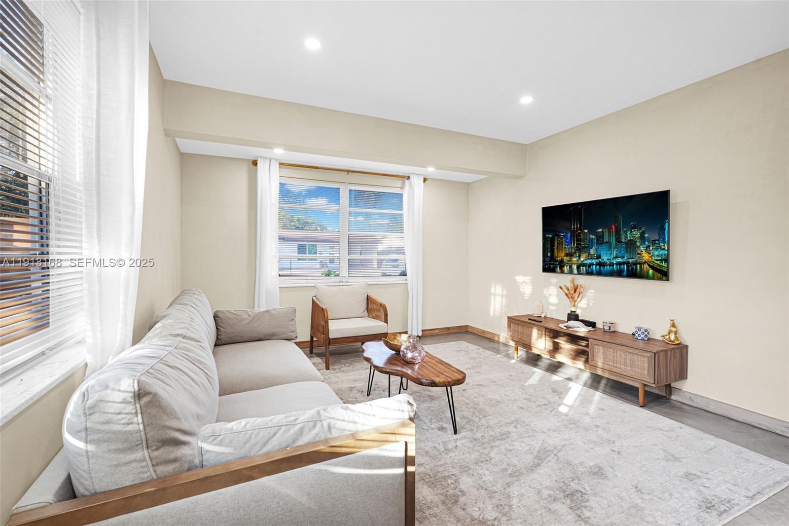 1012 Northeast 2nd Street Hallandale Beach, FL 33009 - Photo 36 of 65 a living room with furniture and a flat screen tv