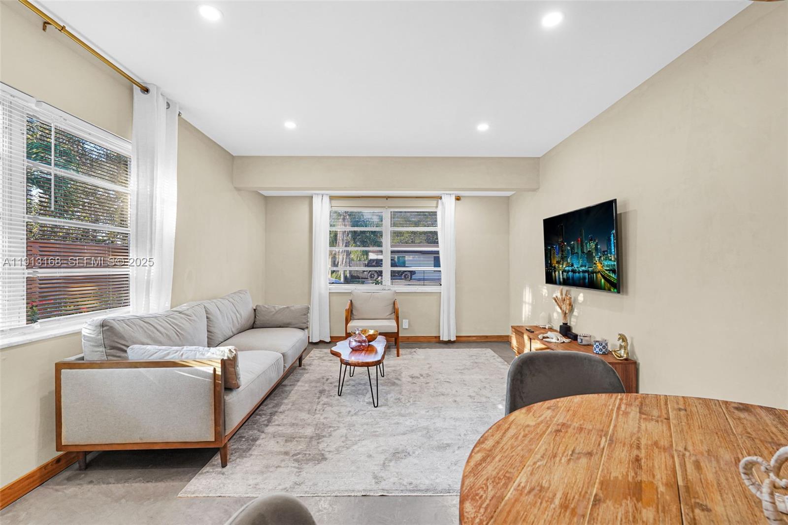 1012 Northeast 2nd Street Hallandale Beach, FL 33009 - Photo 37 of 65 a living room with furniture and a flat screen tv