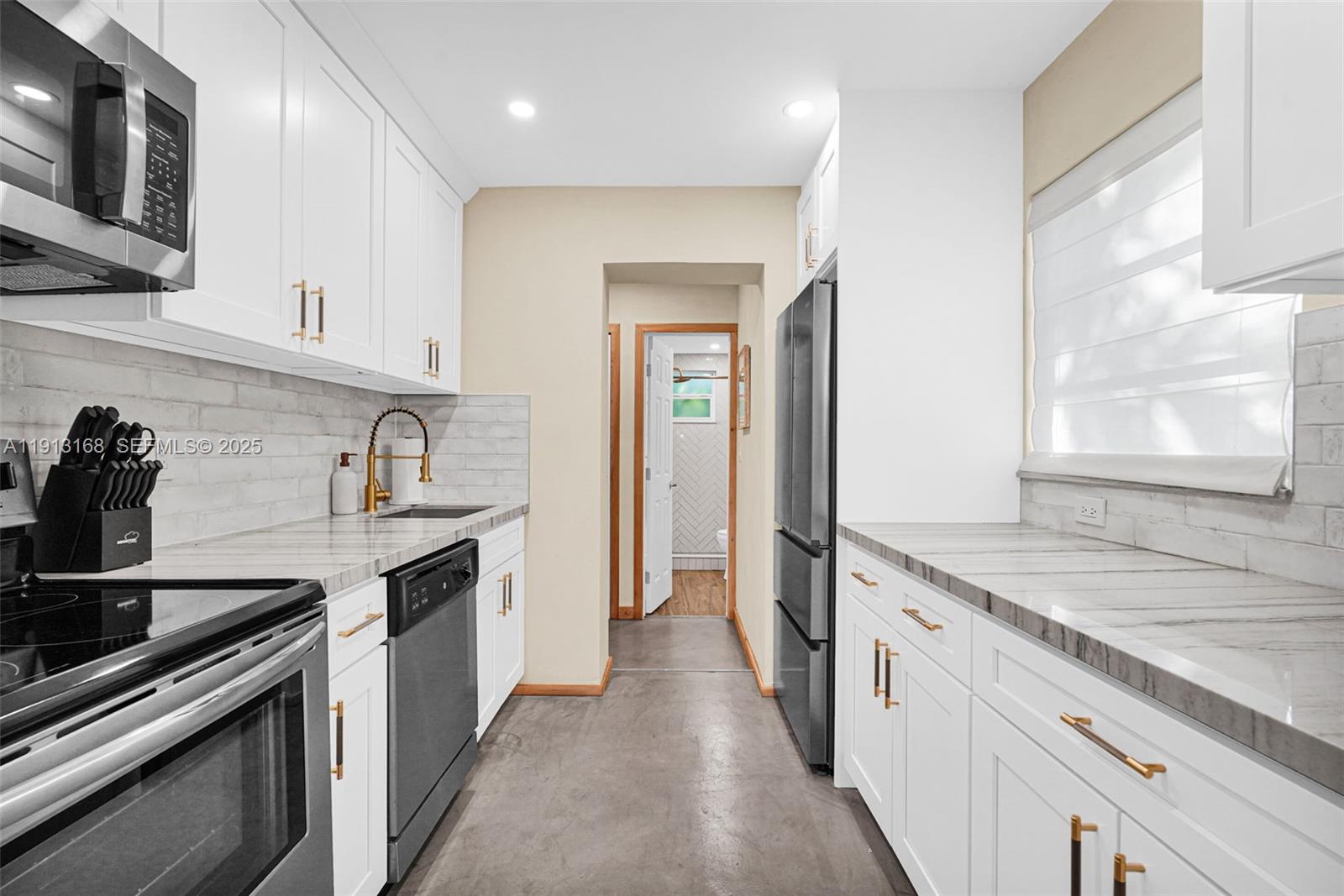 1012 Northeast 2nd Street Hallandale Beach, FL 33009 - Photo 43 of 65 a kitchen with a sink stove and cabinets