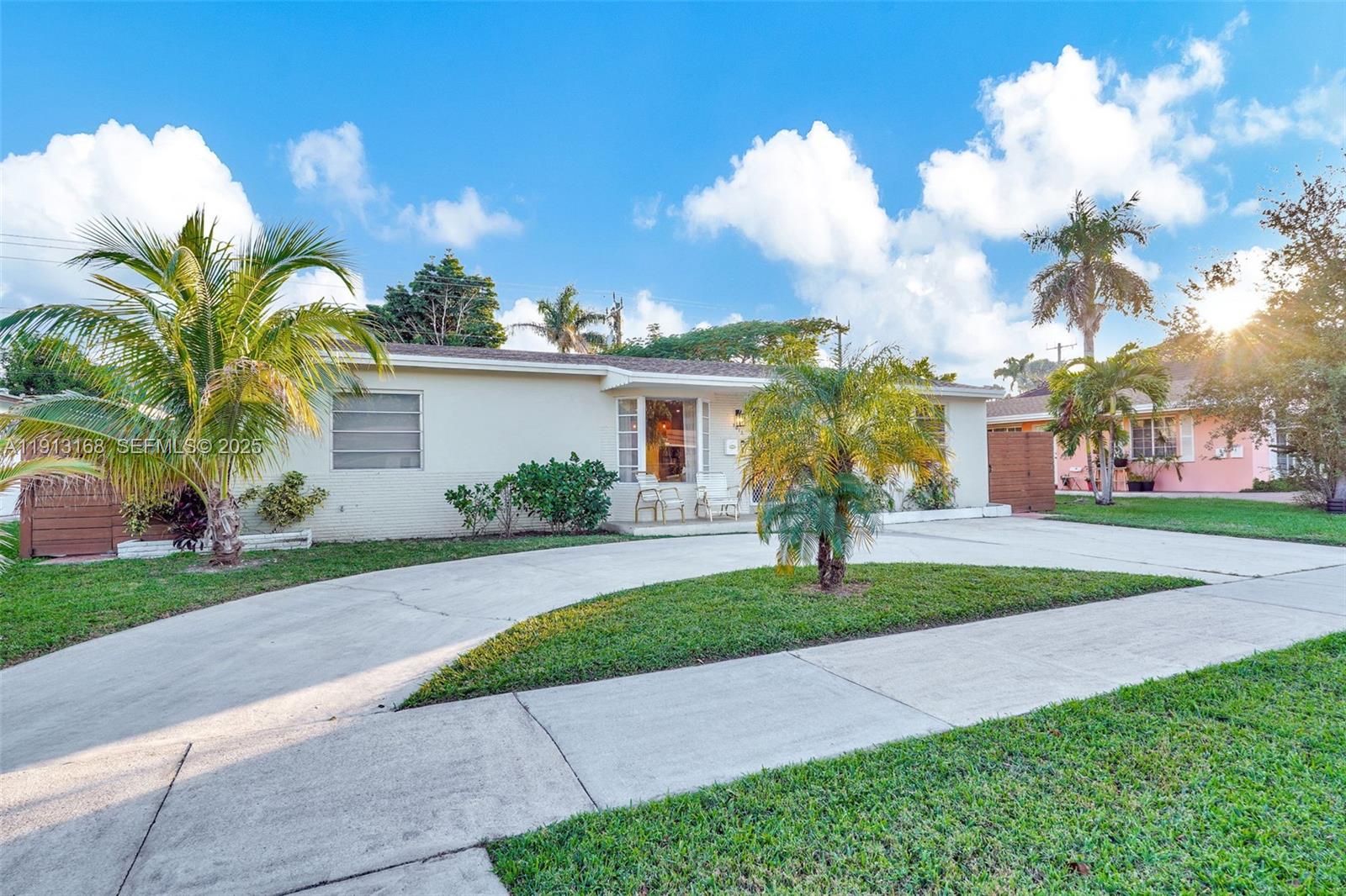 1012 Northeast 2nd Street Hallandale Beach, FL 33009 - Photo 53 of 65 a front view of a house with a garden and trees