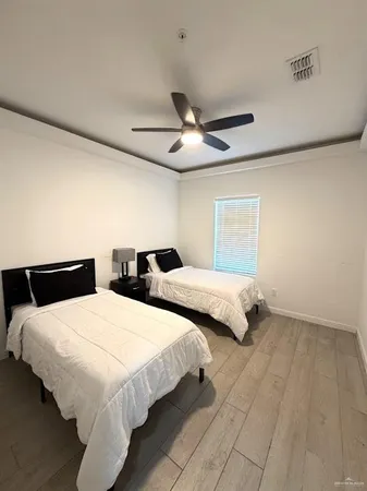 a bedroom with two beds and a ceiling fan