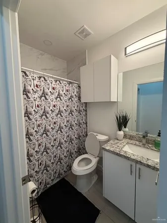 a bathroom with a granite countertop sink toilet and a mirror