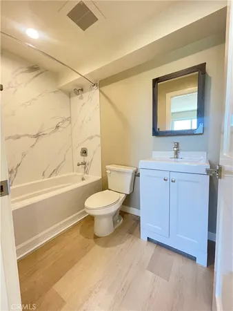 a bathroom with a toilet sink a mirror and shower