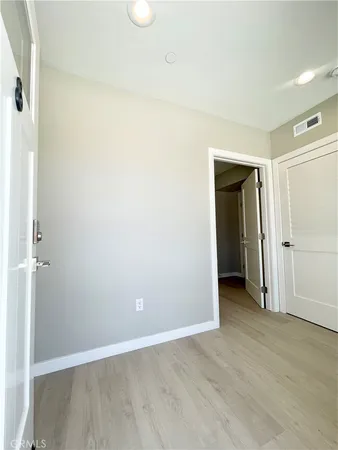 an empty room with wooden floor and closet