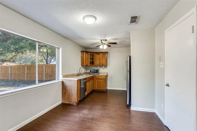a large kitchen with a large window and stainless steel appliances