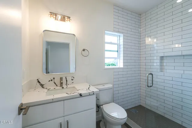 a bathroom with a toilet a sink and mirror