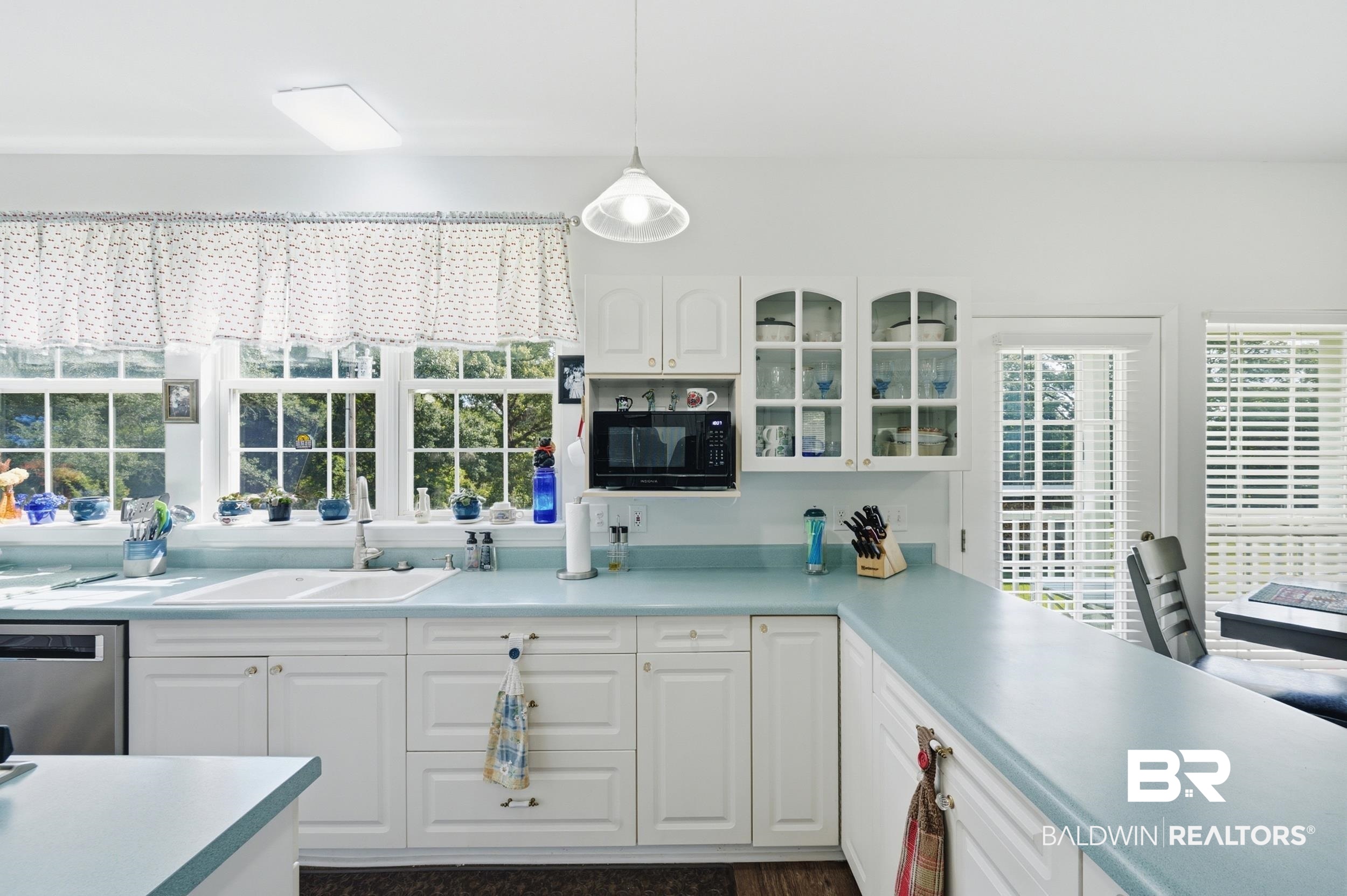 15855 Calvin Richerson Road Bay Minette, AL 36507 - Photo 25 of 83 Bright kitchen featuring extensive perimeter cabinetry, blue countertops, a double basin sink, and a built-in microwave