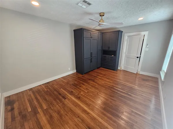 a big room with wooden floor and chandelier fan