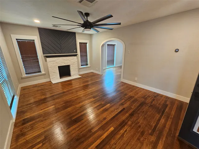 a view of a livingroom with wooden floor and a fireplace