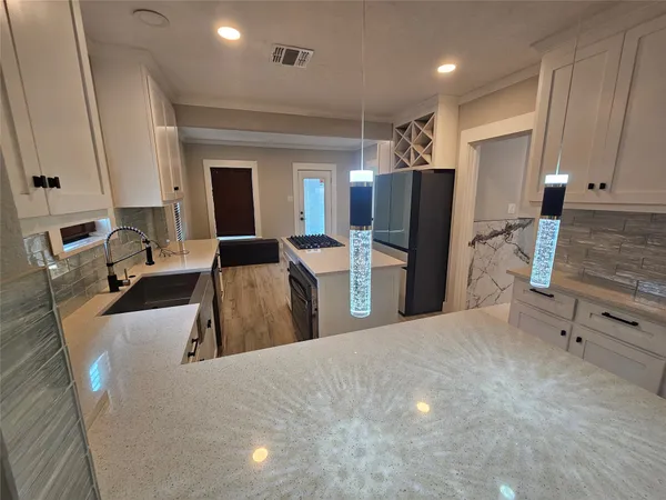 a large kitchen with stainless steel appliances granite countertop a refrigerator and a sink
