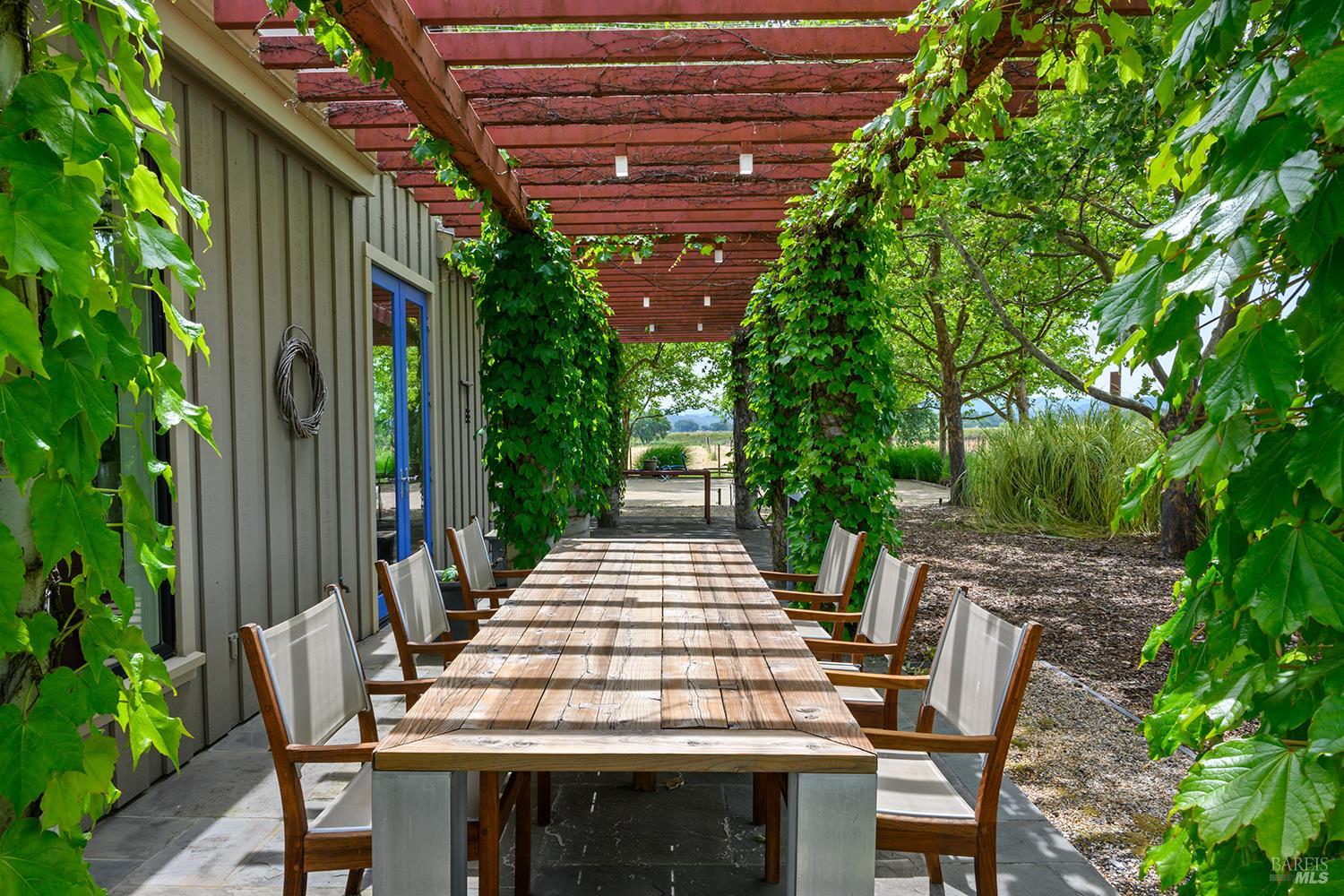 6003-6017 Red Winery Road Geyserville, CA 95441 - Photo 45 of 97 a view of a patio with table and chairs and potted plants