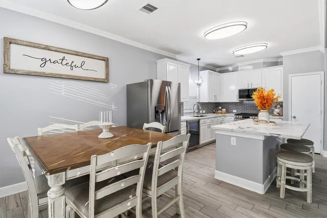 a kitchen with a table chairs refrigerator and microwave