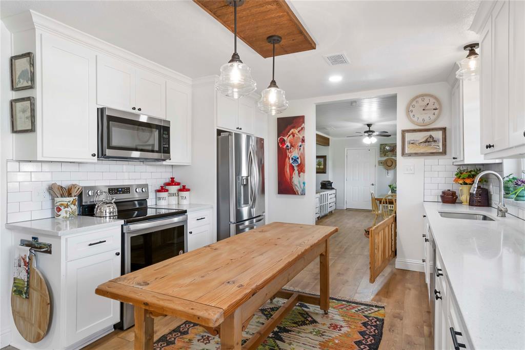 a kitchen with granite countertop a sink appliances and cabinets