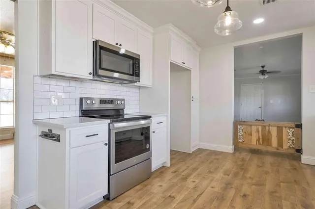 a kitchen with granite countertop a sink cabinets and stainless steel appliances