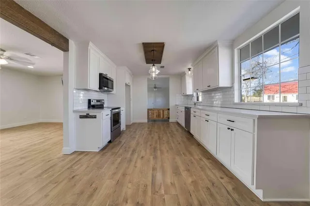 a view of a kitchen with refrigerator and wooden floor