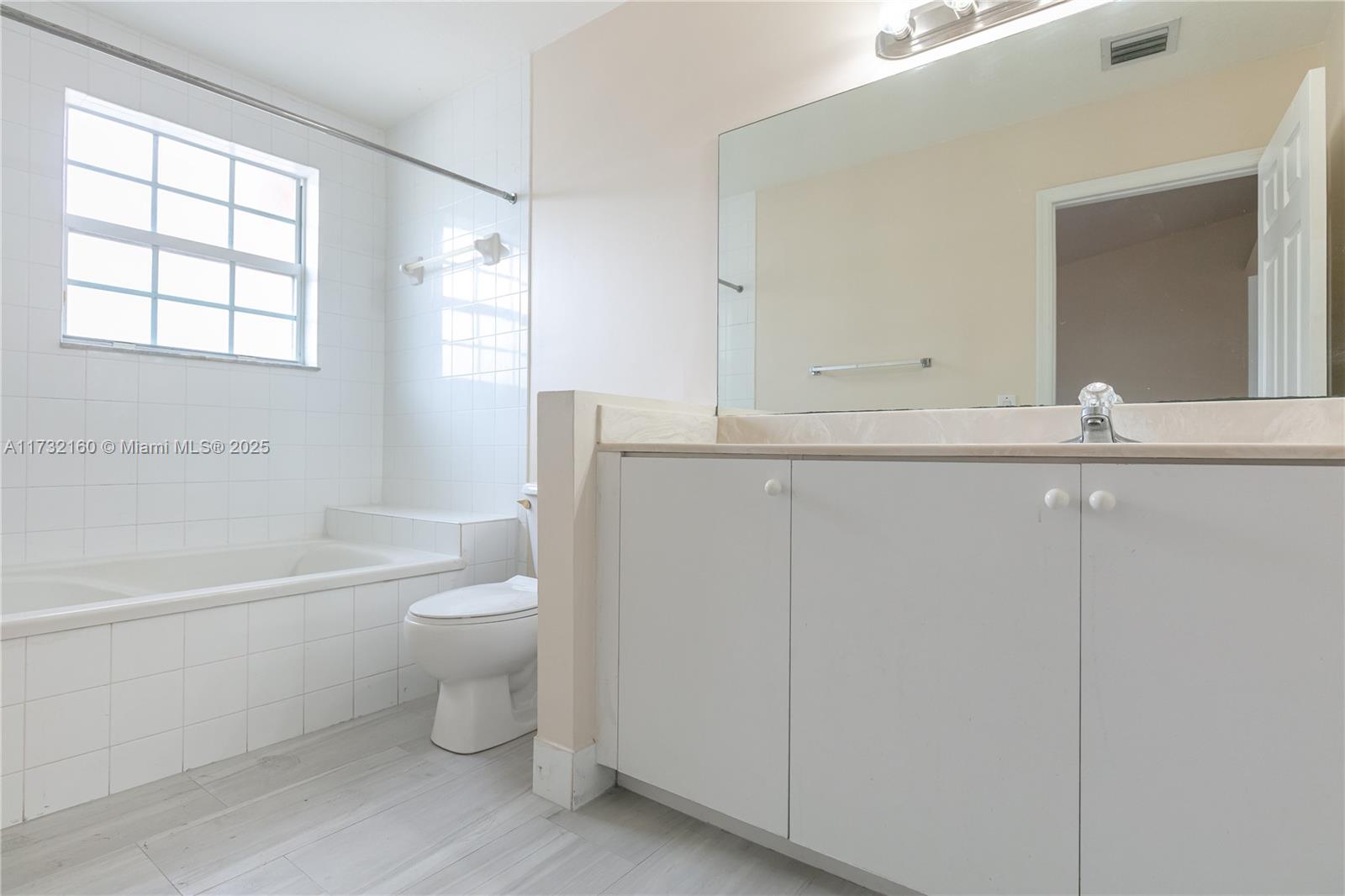 Spring Tree Sunrise, FL 33351 - Photo 15 of 44 a bathroom with a toilet a sink a mirror a bathtub and vanity