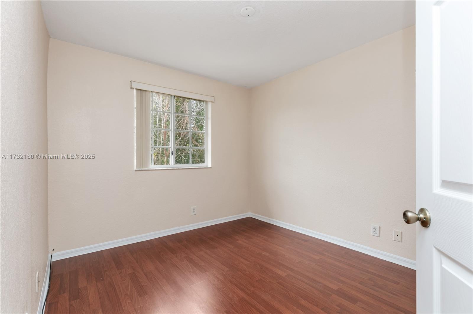 Spring Tree Sunrise, FL 33351 - Photo 31 of 44 an empty room with a window and wooden floor