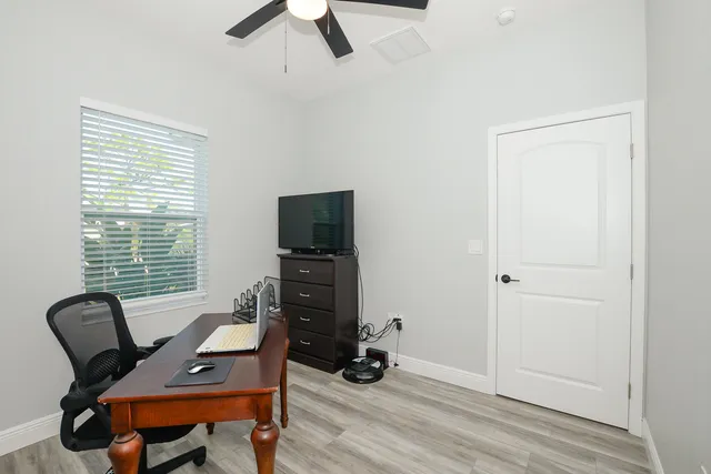 a view of a workspace with furniture and a window