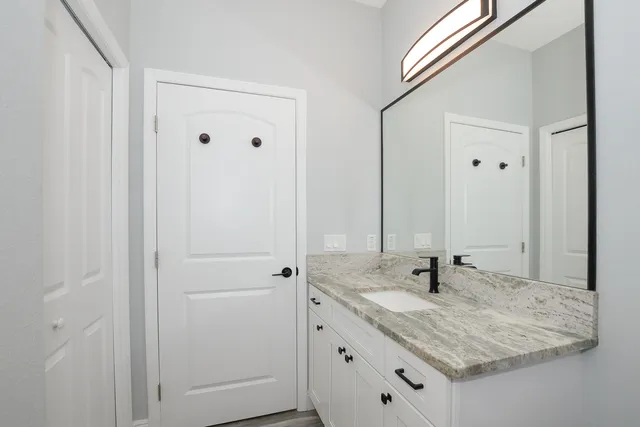 a bathroom with a granite countertop sink and a mirror