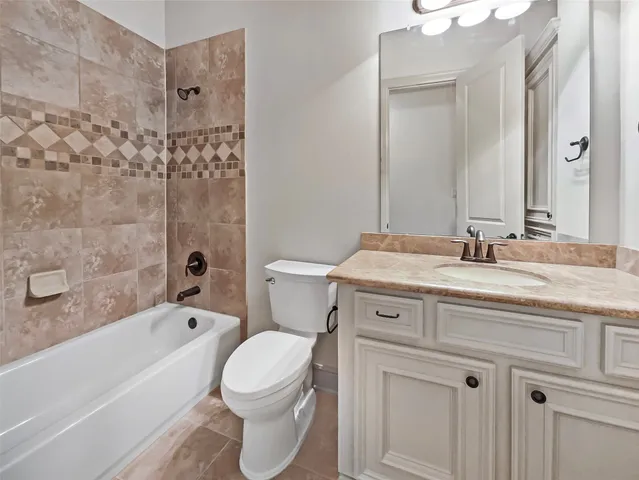 a bathroom with a granite countertop toilet a sink and bathtub