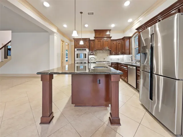 a kitchen with stainless steel appliances granite countertop a refrigerator and a sink
